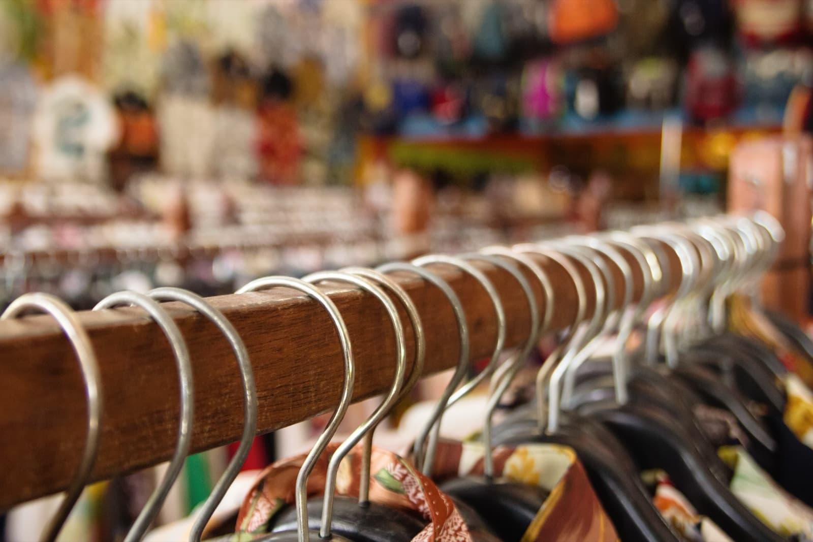 Perchero de madera con ropa de segunda mano en una tienda
